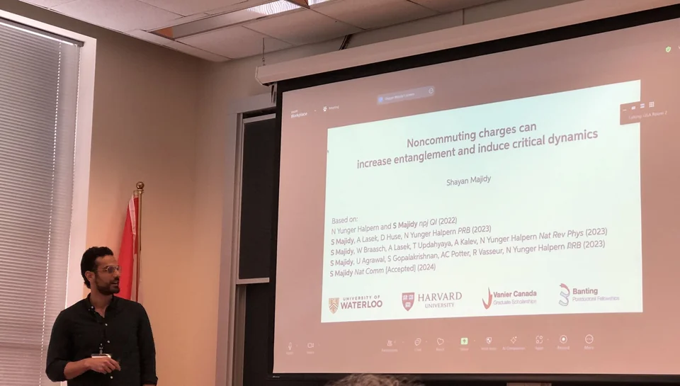 Giving a talk in front of a slide titled Noncommuting charges can increase entanglement and induce critical dynamics
